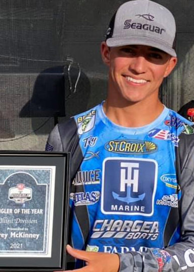 Trey McKinney on stage holding the 2022 BFL Angler of the Year award.