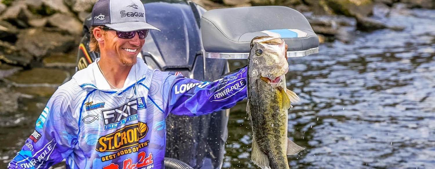 Photo of Trey McKinney holding a large bass. His jersey prominently features sponsors such as FXR Pro Fish, St. Croix Rods, Power-Pole and Seaguar.